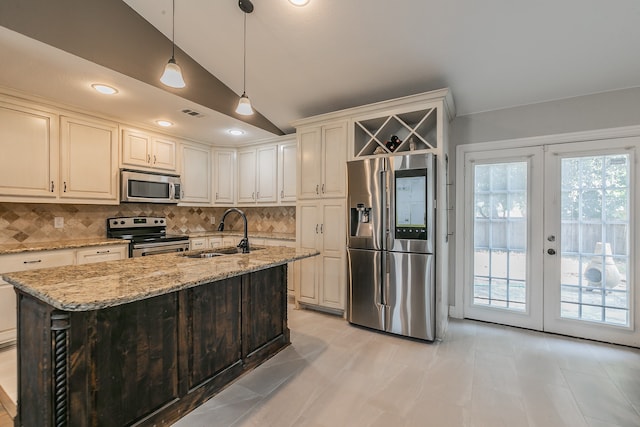 kitchen with appliances with stainless steel finishes, tasteful backsplash, sink, light stone countertops, and light tile patterned flooring