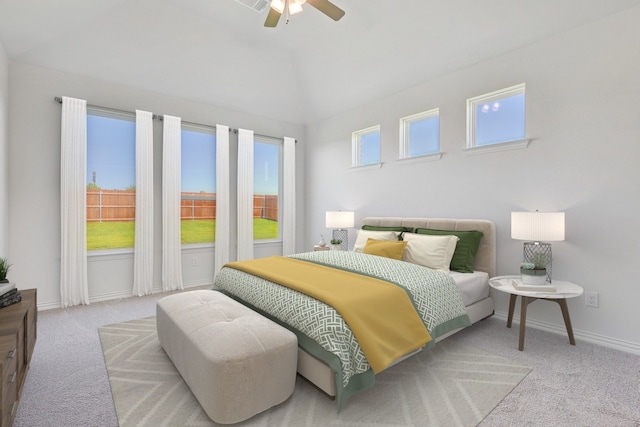 bedroom featuring multiple windows, vaulted ceiling, light colored carpet, and ceiling fan