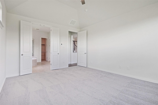 unfurnished bedroom with ceiling fan, vaulted ceiling, and light carpet