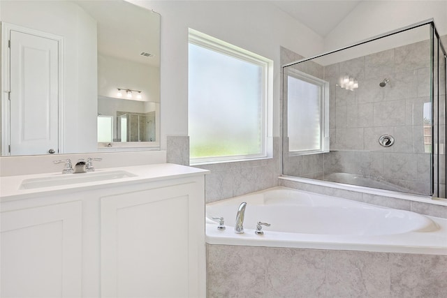 bathroom with vanity, lofted ceiling, and separate shower and tub