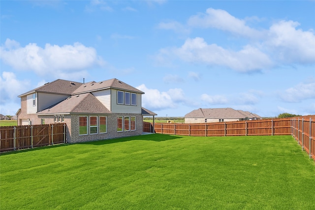 rear view of house featuring a yard