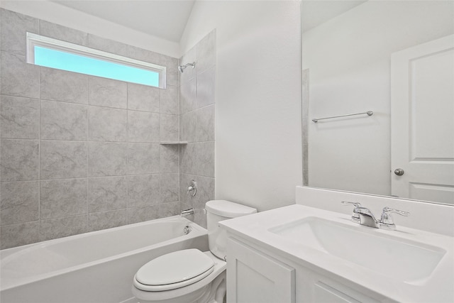 full bathroom with tiled shower / bath, vanity, lofted ceiling, and toilet