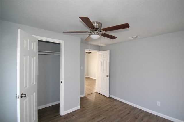 unfurnished bedroom featuring dark hardwood / wood-style flooring, a closet, and ceiling fan