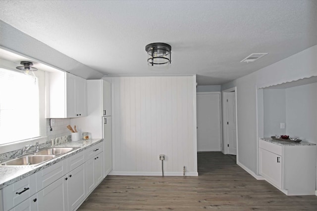 kitchen featuring sink, white cabinetry, a textured ceiling, and dark wood-type flooring