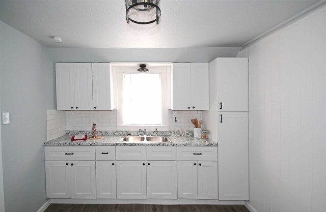 kitchen featuring sink, dark hardwood / wood-style flooring, white cabinets, and decorative backsplash