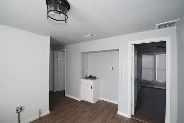 hallway with dark hardwood / wood-style floors and a textured ceiling