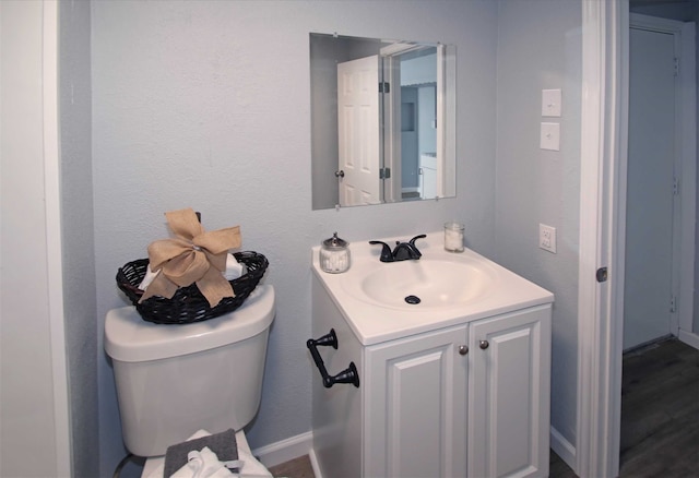 bathroom with vanity, wood-type flooring, and toilet