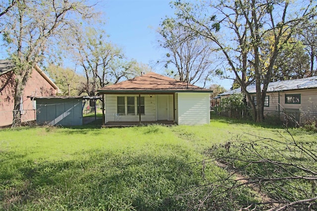 rear view of property featuring a lawn