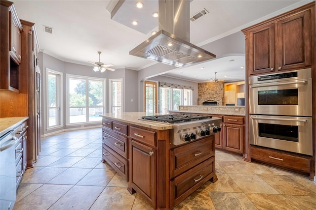 kitchen featuring island range hood, a kitchen island, ornamental molding, and appliances with stainless steel finishes