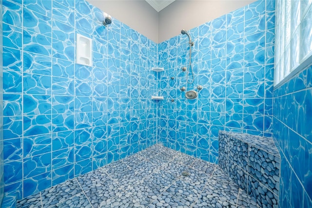 bathroom featuring ornamental molding and tiled shower