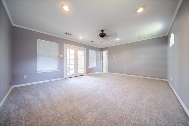 carpeted empty room with crown molding, french doors, and ceiling fan