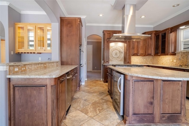 kitchen featuring backsplash, light stone countertops, kitchen peninsula, island exhaust hood, and beverage cooler