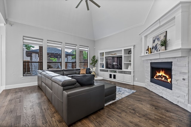 living room featuring lofted ceiling, dark wood-type flooring, crown molding, a fireplace, and ceiling fan