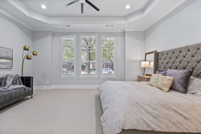 carpeted bedroom featuring ceiling fan, crown molding, and a tray ceiling