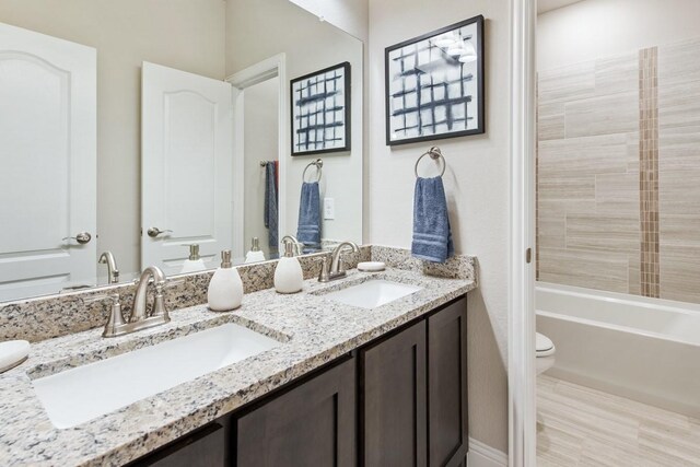 full bathroom with washtub / shower combination, vanity, and toilet