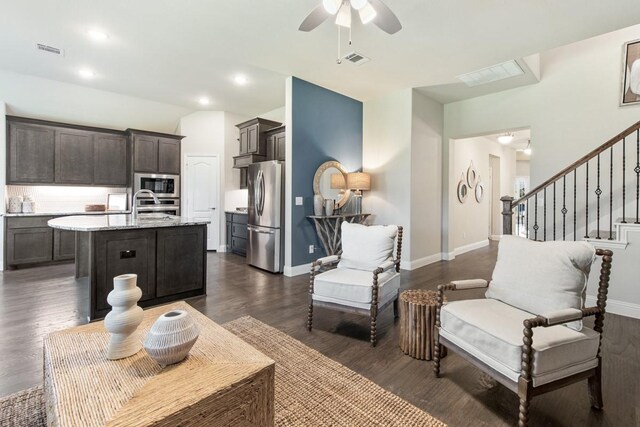 living room featuring ceiling fan and dark hardwood / wood-style flooring