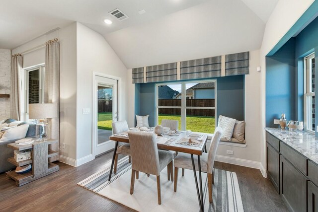 dining area featuring lofted ceiling and dark hardwood / wood-style floors