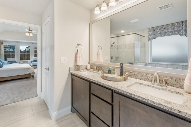 bathroom with vanity, a shower with door, and ceiling fan