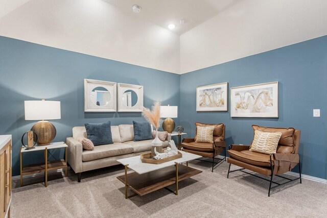 carpeted living room with high vaulted ceiling