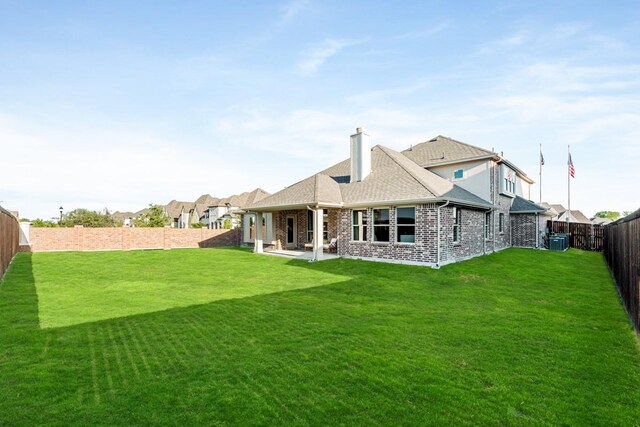 back of house with a patio area and a lawn