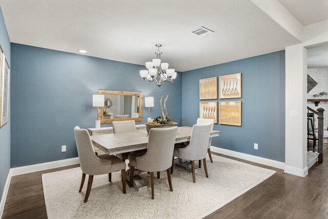 dining space featuring wood-type flooring and a notable chandelier