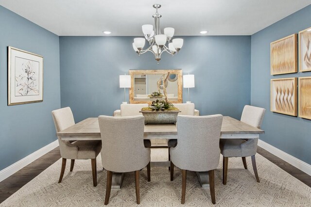 dining room with hardwood / wood-style floors and a notable chandelier