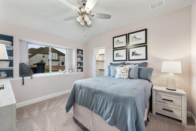 carpeted bedroom featuring lofted ceiling, ensuite bath, and ceiling fan