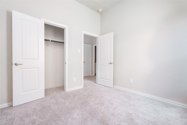 unfurnished bedroom featuring light colored carpet and a closet