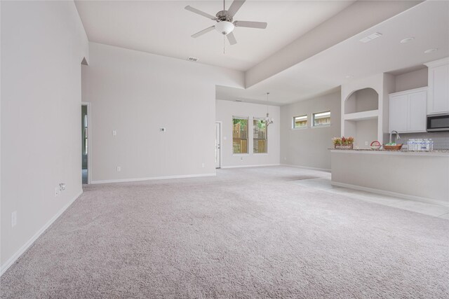 unfurnished living room with light carpet and ceiling fan