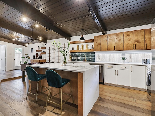 kitchen featuring a kitchen island, wooden ceiling, and white cabinets