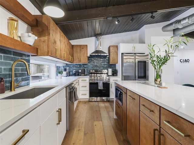 kitchen with sink, hanging light fixtures, appliances with stainless steel finishes, decorative backsplash, and white cabinets