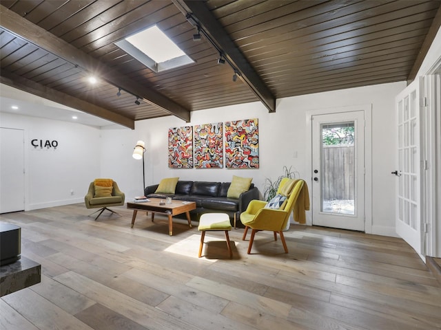 interior space with beamed ceiling, rail lighting, wood ceiling, and light hardwood / wood-style floors