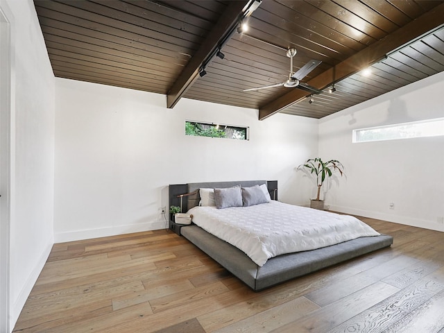 bedroom featuring light hardwood / wood-style floors, wooden ceiling, rail lighting, and ceiling fan