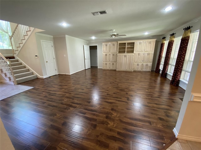 unfurnished living room with visible vents, a ceiling fan, stairway, and dark wood-style flooring