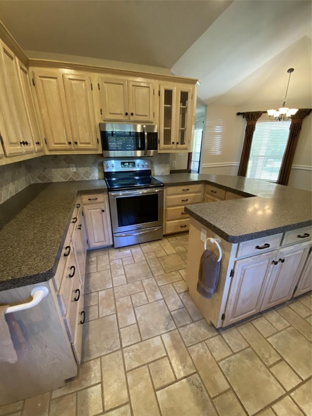 kitchen with stone tile flooring, stainless steel appliances, light brown cabinetry, and a chandelier