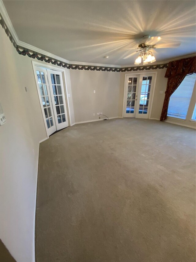 carpeted empty room with french doors, ornamental molding, and baseboards