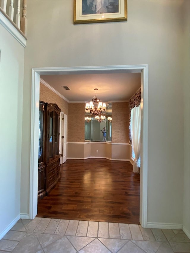 interior space featuring baseboards, visible vents, light wood-style flooring, and a chandelier