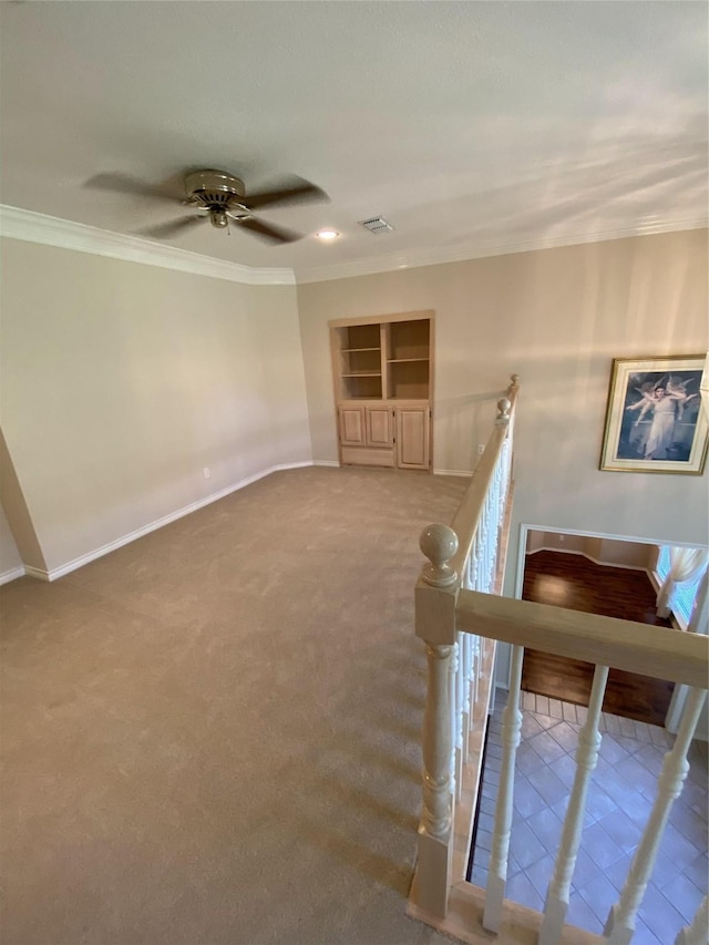 stairs featuring carpet flooring, visible vents, crown molding, baseboards, and a ceiling fan