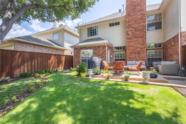 rear view of property featuring outdoor lounge area, a yard, and a patio area