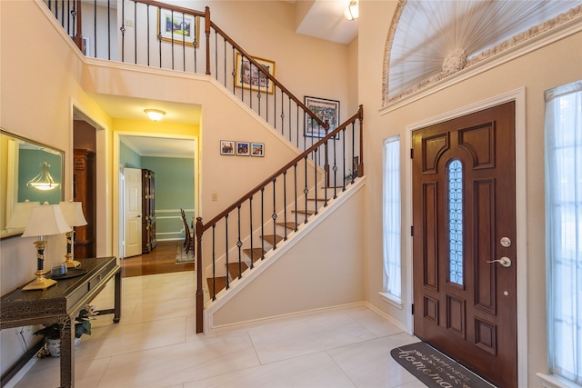 tiled foyer with a healthy amount of sunlight and a high ceiling