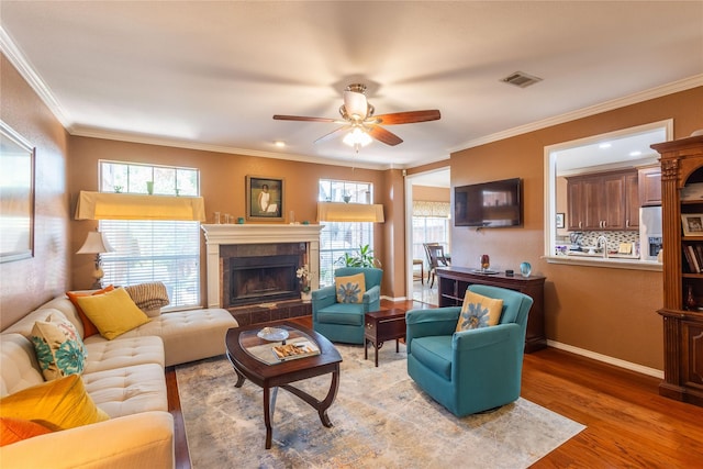 living room featuring hardwood / wood-style flooring, ornamental molding, and a wealth of natural light