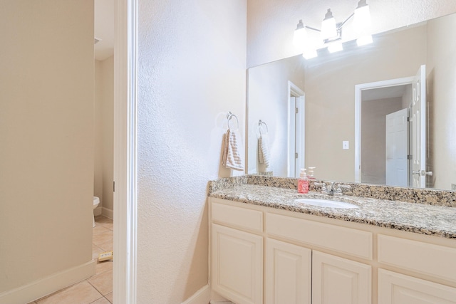 bathroom with vanity, toilet, and tile patterned floors