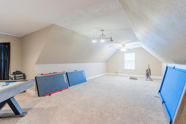 interior space featuring vaulted ceiling, a textured ceiling, ceiling fan, and carpet flooring