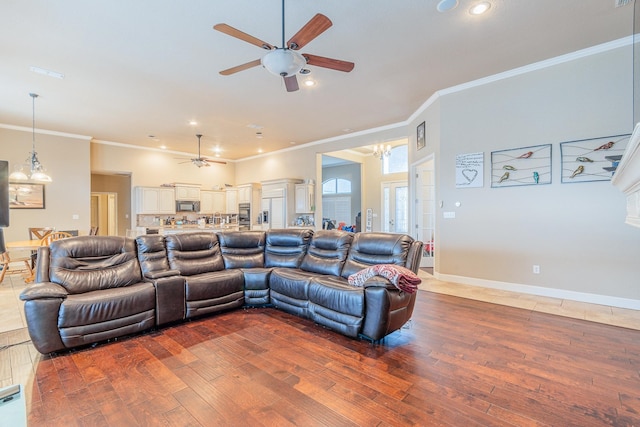 living room with ceiling fan, crown molding, and hardwood / wood-style flooring