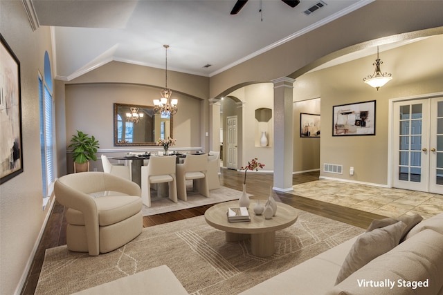 living room featuring hardwood / wood-style flooring, ornamental molding, ceiling fan with notable chandelier, and decorative columns