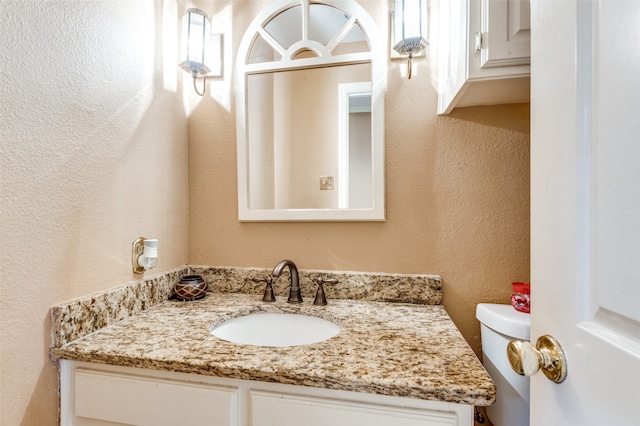 bathroom featuring toilet and vanity