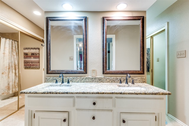 bathroom with dual vanity and tile patterned flooring