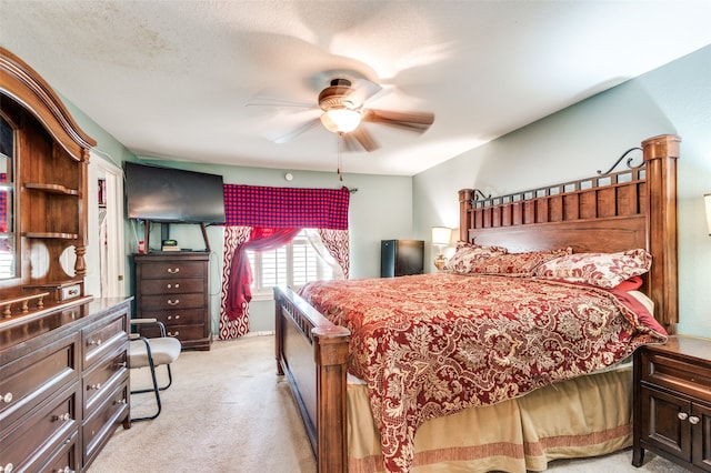 bedroom with a textured ceiling, ceiling fan, and light colored carpet