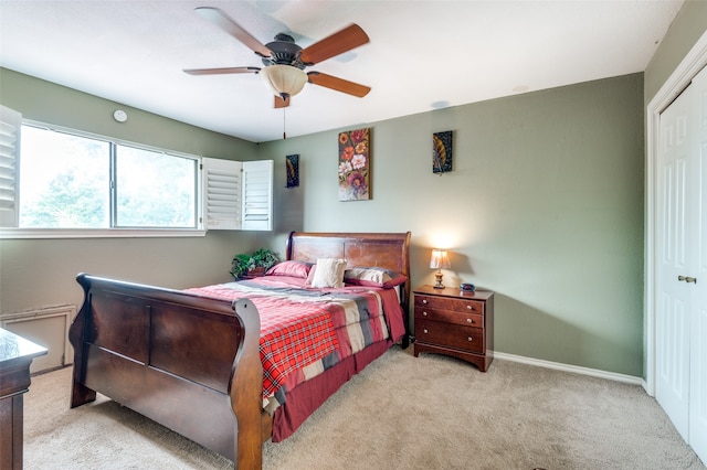 carpeted bedroom featuring ceiling fan and a closet