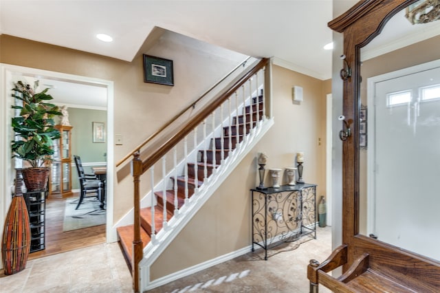 stairway featuring crown molding and light hardwood / wood-style flooring